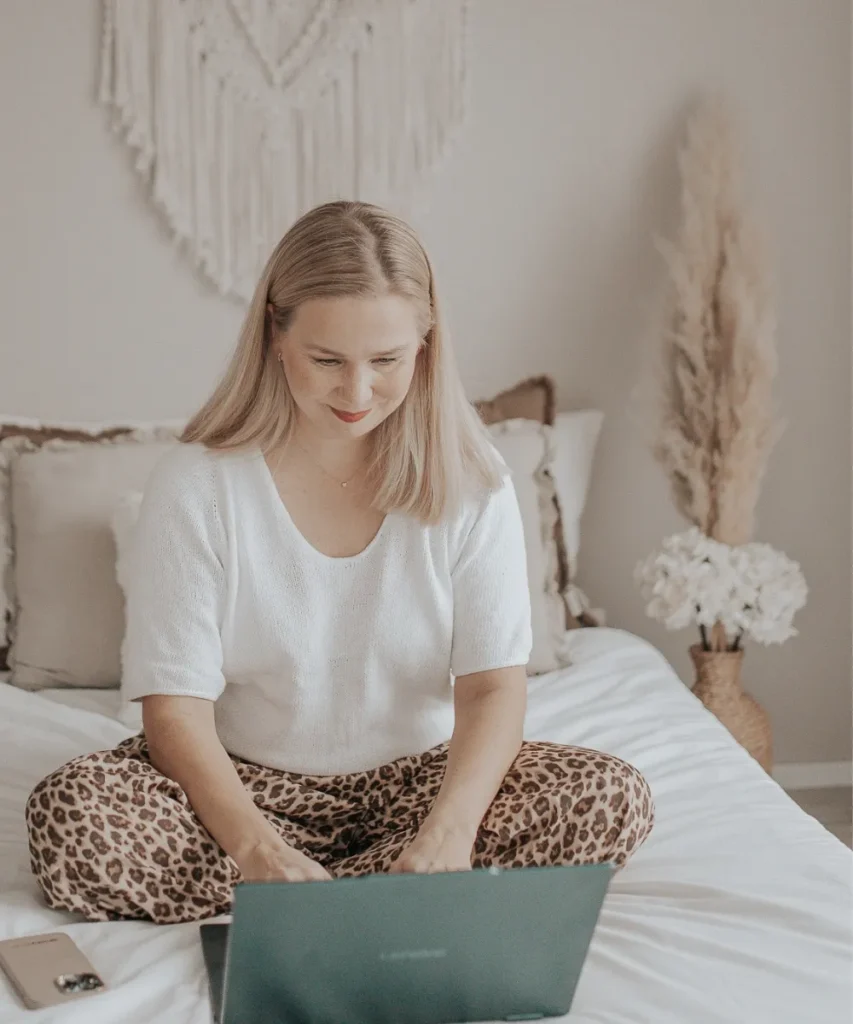 digitalflowkit-about-working-on-laptop DigitalFlowKit owner Benita sitting on a couch and working on Shopify email templates