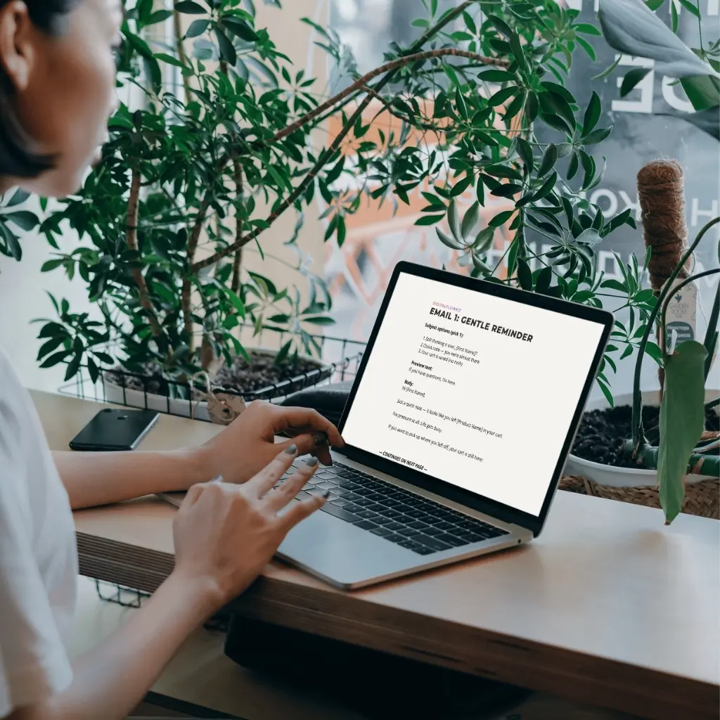 Person viewing a DigitalFlowKit Cart Abandonment email template on a laptop.